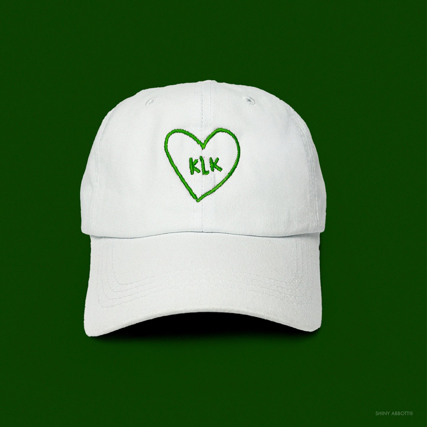 White Baseball Cap with Green KLK Heart Embroidery